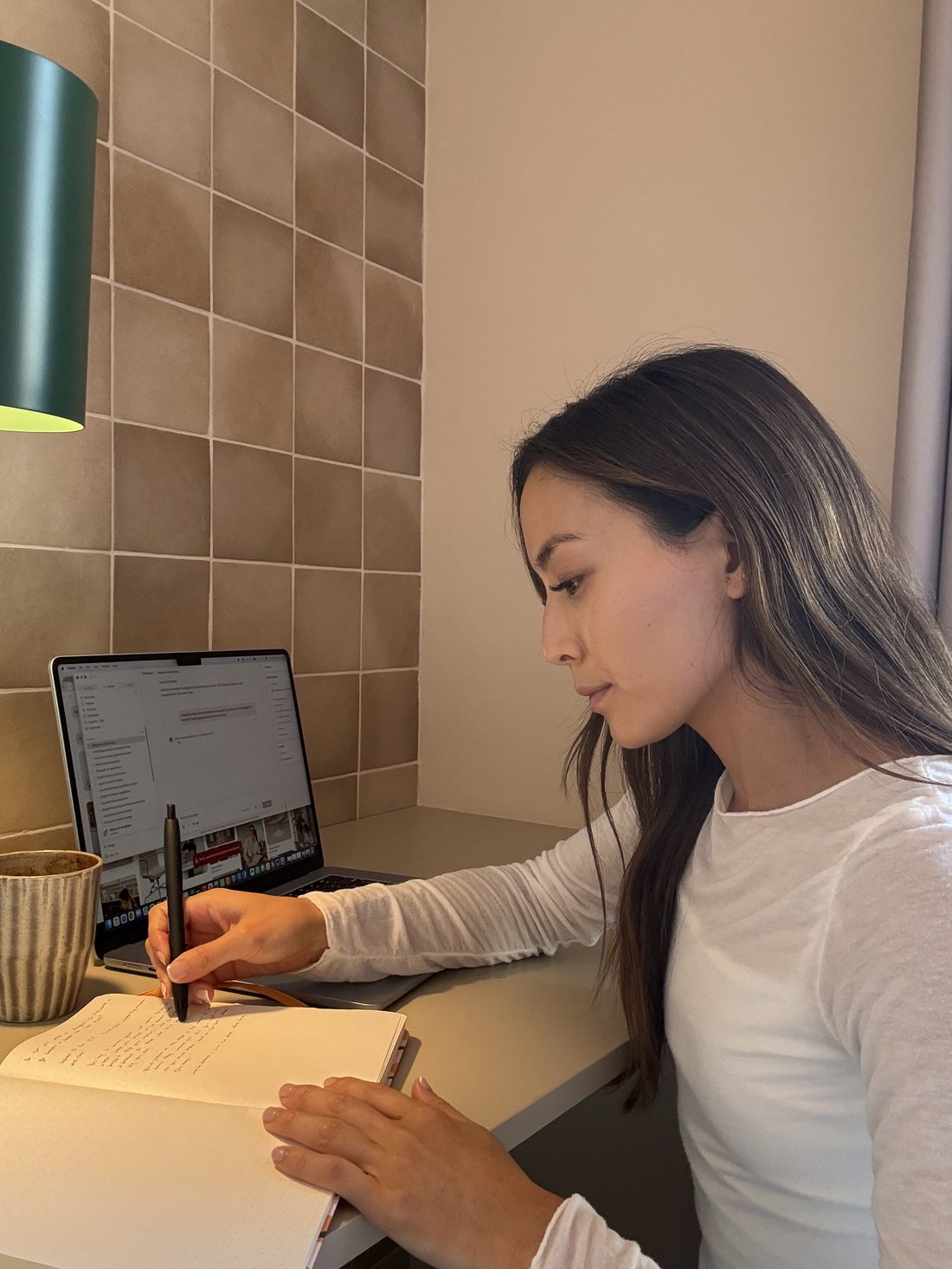 Lina, founder of Kind Chaos, journaling at her desk